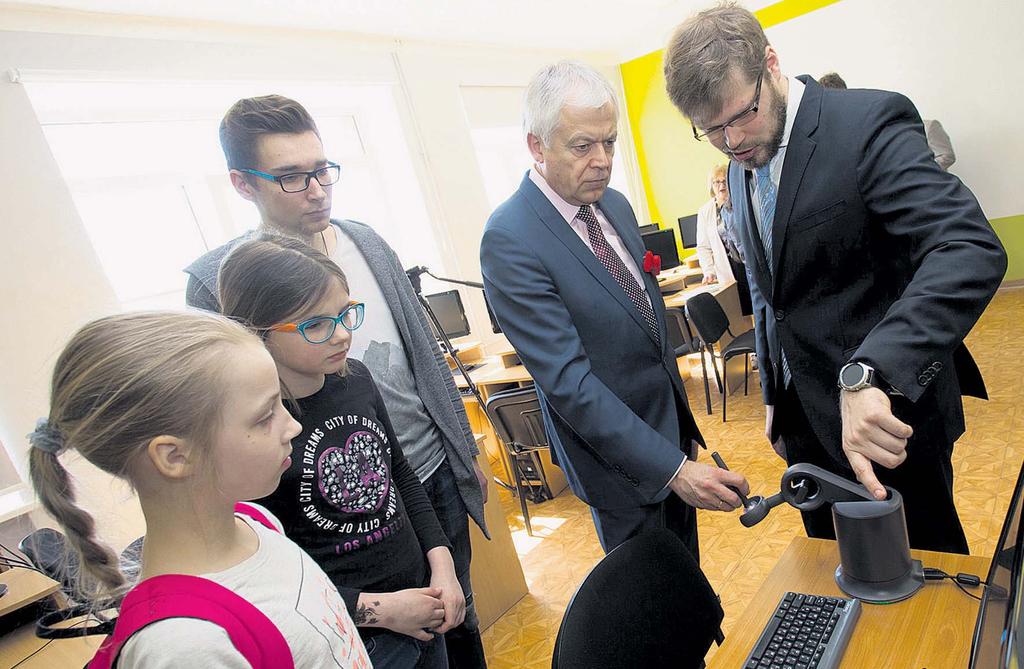 EU pārstāvis Didzis Dejus (pirmais no labās) Liepājas novada domes priekšsēdētājam Uldim Seskam un Liepājas Raiņa 6. vidusskolas skolēniem demonstrē iekārtas jaunatvērtajā 3D printeru klasē.